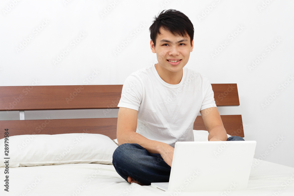 Man on a bed with his laptop