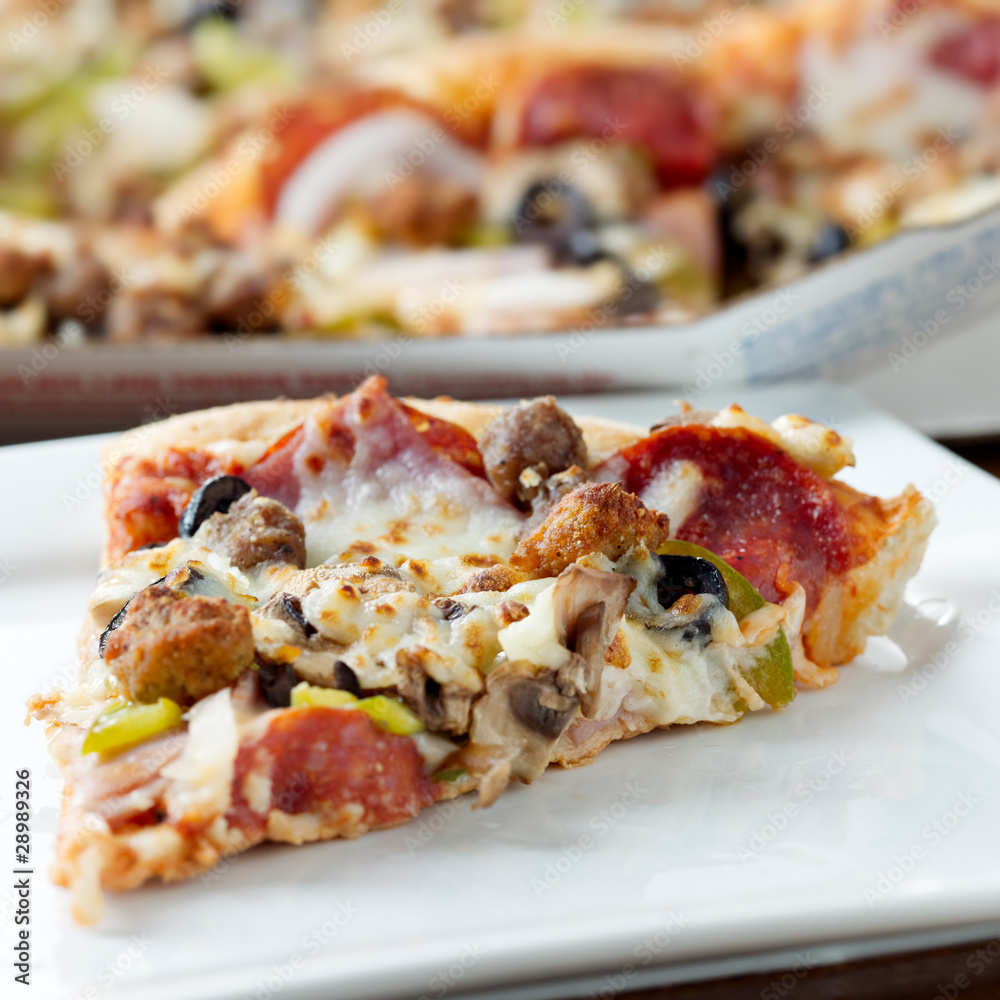 slice of pizza on a plate with pereroni and black olives slice of pizza on a plate with pereroni and black olives