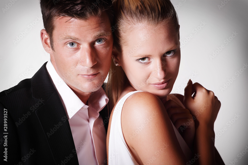 Attractive young couple. Studio portrait on grey background.