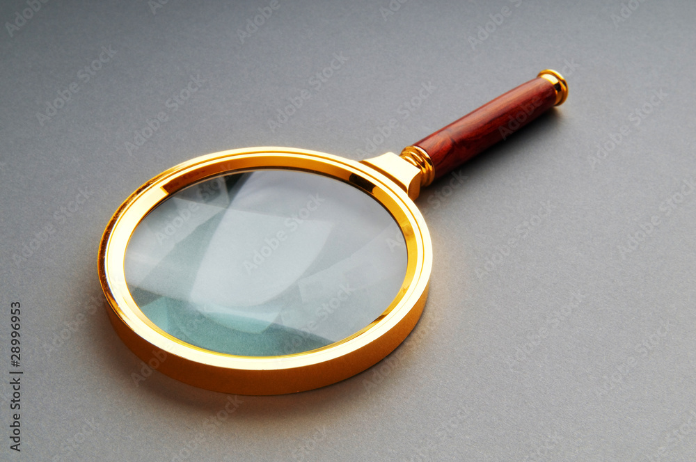 Magnifying glass with wooden handle on the flat surface