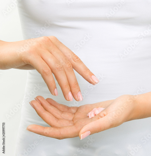 Beautiful woman's hands with care cream