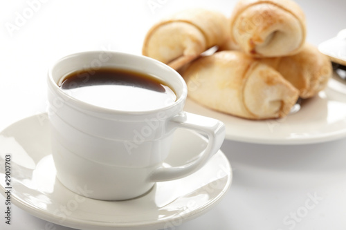 Cup of coffee with a roll