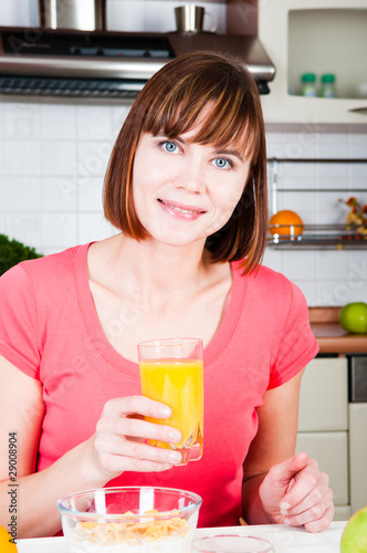 Young woman drinking orange juice at home