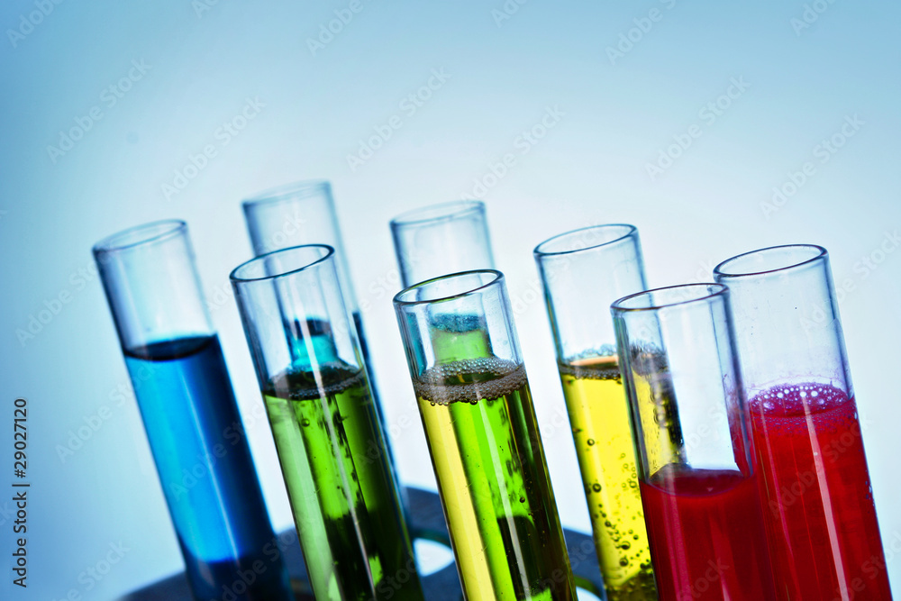 Multicoloured test tubes in the stand on blue background Multicoloured test tubes in the stand on blue background