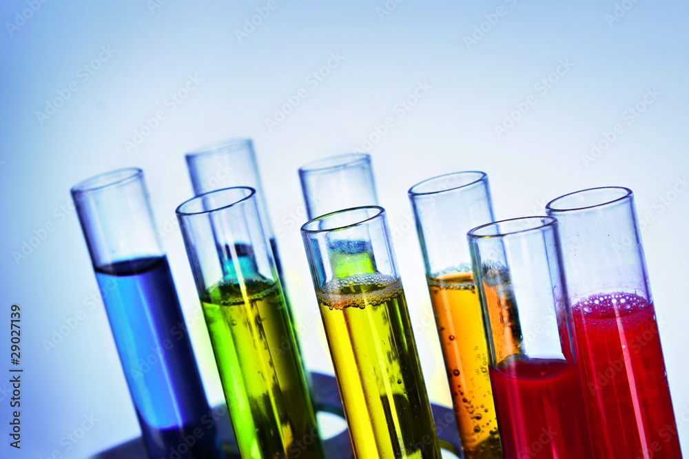 Multicoloured test tubes in the stand on blue background Multicoloured test tubes in the stand on blue background