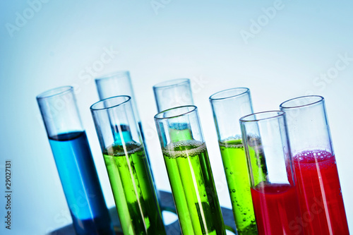 Multicoloured test tubes in the stand on blue background