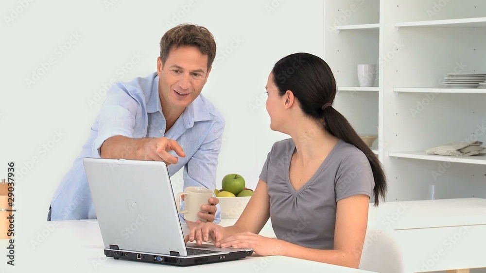 Woman working on the laptop with her husband Woman working on the laptop with her husband