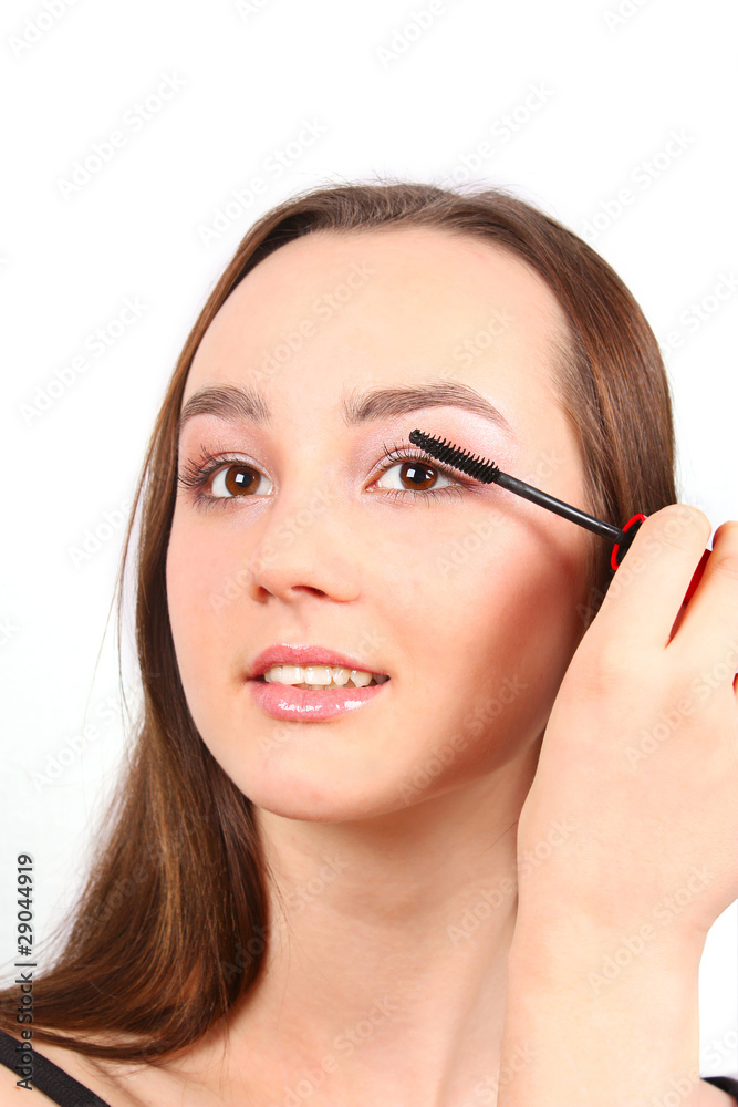 Portrait of Beautiful brunette girl applying mascara