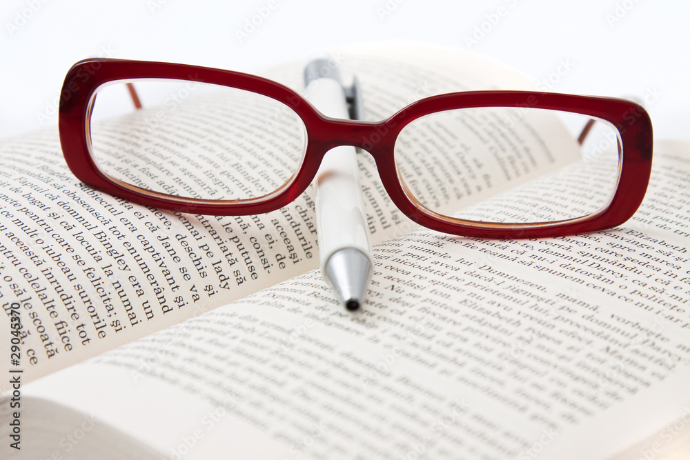 Glasses on book and pen isolated in white Glasses on book and pen isolated in white