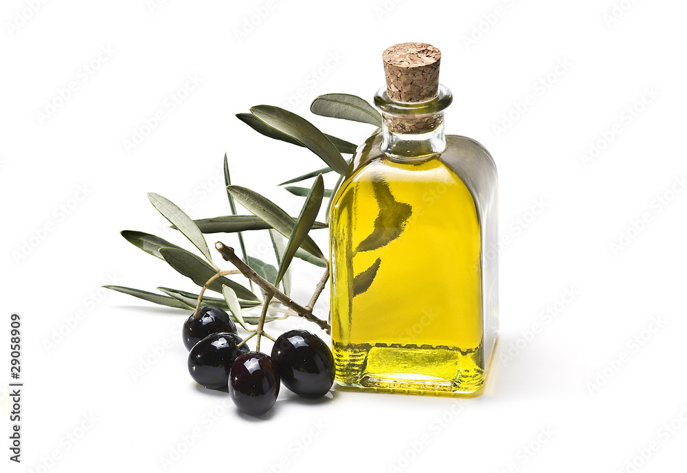 Rama de olivo con olivas negras y su aceite embotellado.