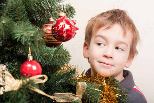 Boy looks out for the christmas treechristmas tree photo