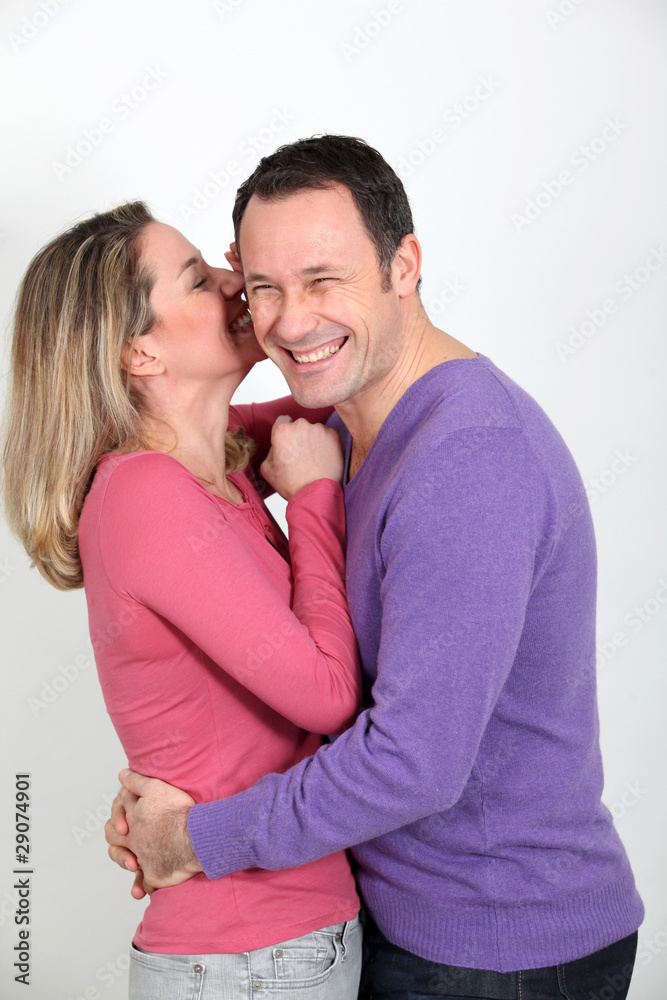 Woman whispering to her boyfriend's ear Woman whispering to her boyfriend's ear