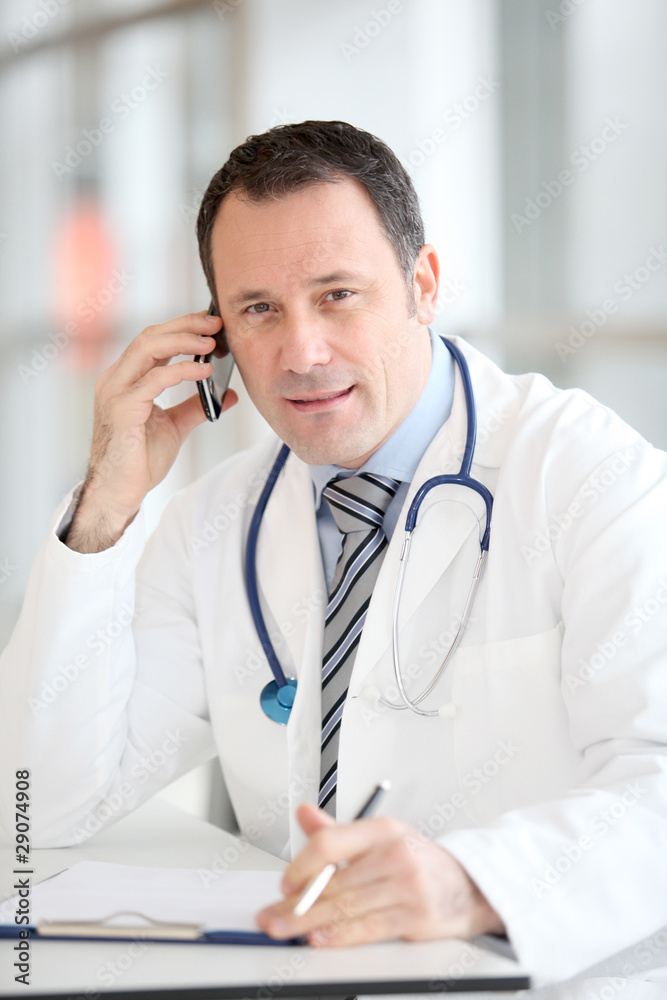 Portrait of handsome doctor talking on the phone