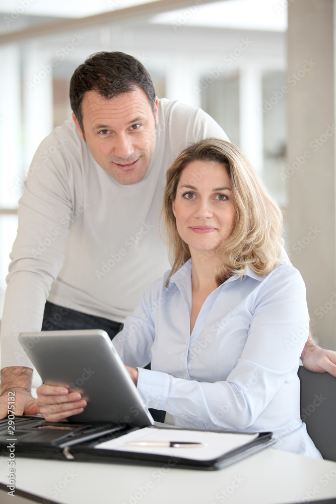 Office workers using electronic tab in the office Office workers using electronic tab in the office