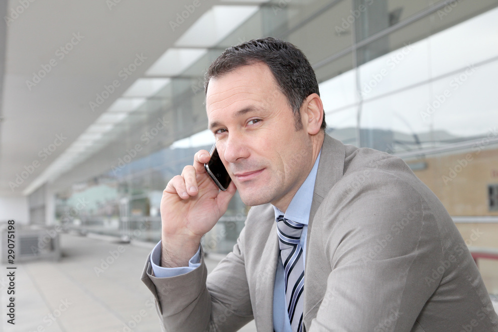 Salesman talking on the phone outside congress center Salesman talking on the phone outside congress center