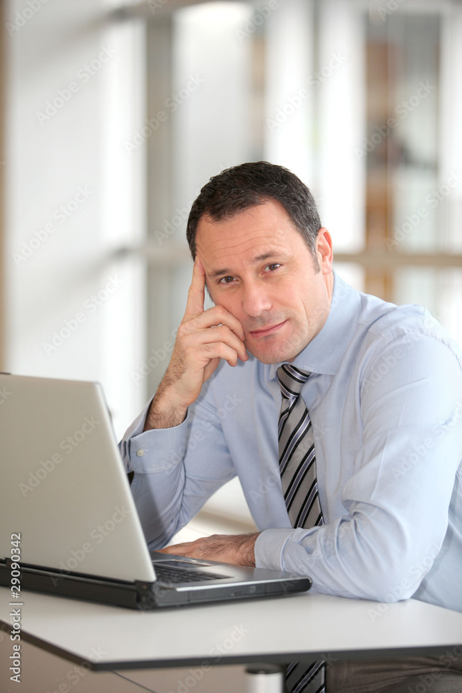 Portrait of businessman in front of laptop computer Portrait of businessman in front of laptop computer