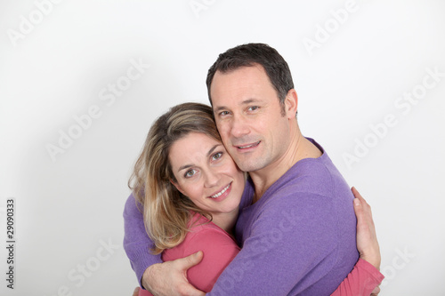 Portrait of in loved couple standing on white background © goodluz