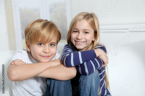 Portrait of young children sitting in sofa at home