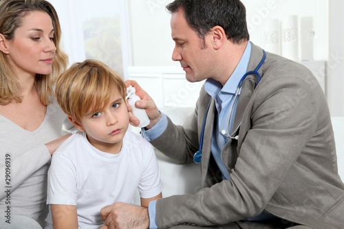 Doctor cheking little boy's ear infection