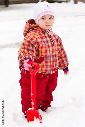 Child playing with spade in snow
