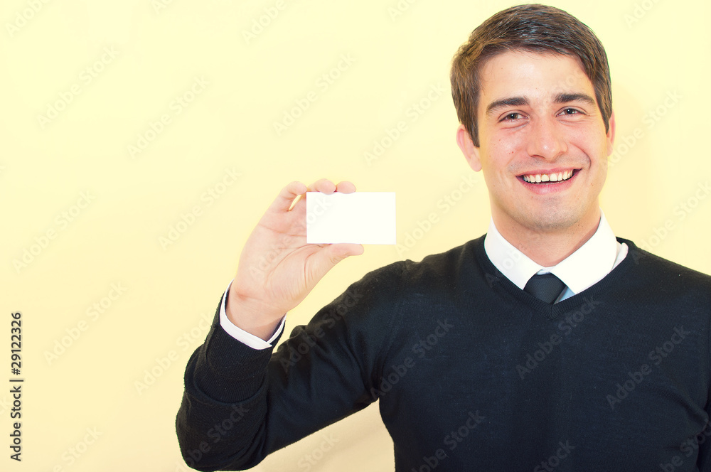Young smiling handsome business man showing a blank business car