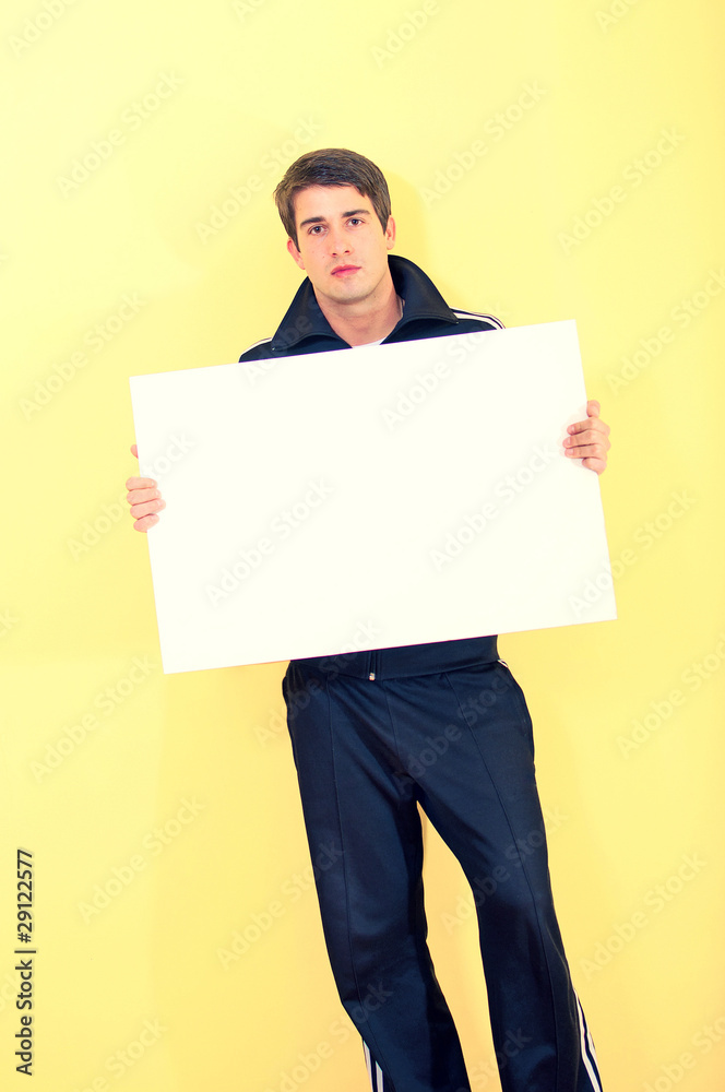 Portrait of an handsome young man in track suit holding blank wh Portrait of an handsome young man in track suit holding blank wh