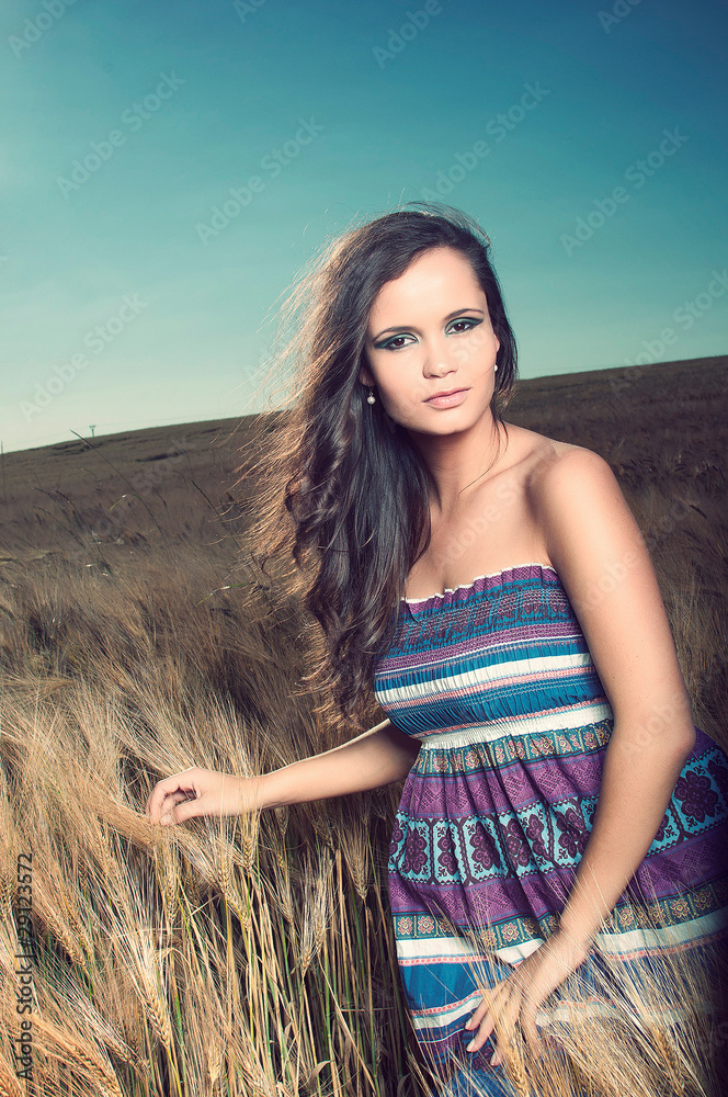young beautiful woman in dress in golden wheat field young beautiful woman in dress in golden wheat field