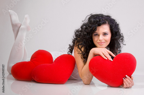 Romantic concept with girl and heart-shaped pillows