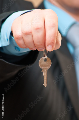 concept image of a businessman holding a key