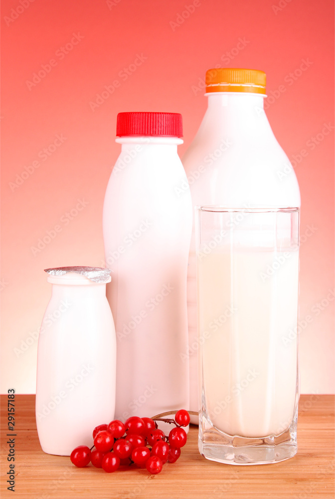 glass of milk and bottle on red background glass of milk and bottle on red background
