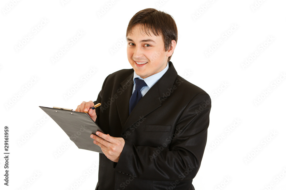 Smiling young businessman making notes in document Smiling young businessman making notes in document