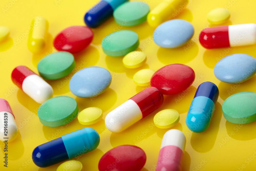 Colorful pills over yellow background Colorful pills over yellow background