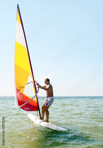 Windsurfing man in sea lagoon