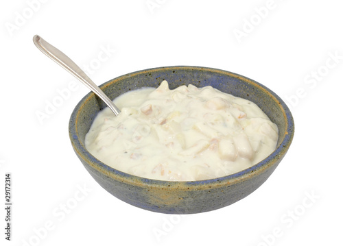 Clam chowder in old bowl with spoon