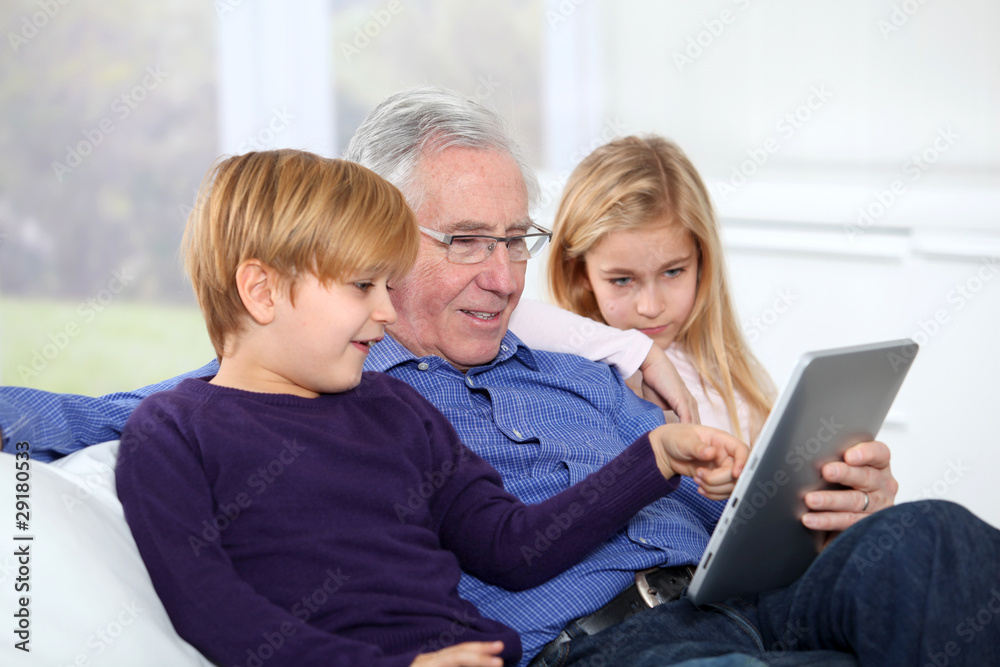Grandfather with kids using electronic tab Grandfather with kids using electronic tab