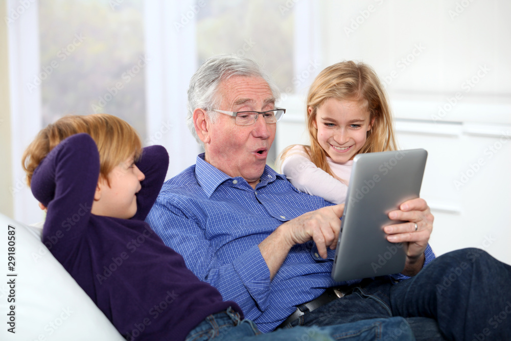 Grandfather with kids using electronic tab Grandfather with kids using electronic tab