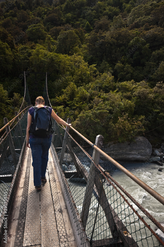 Woman passing a suspension bridge
