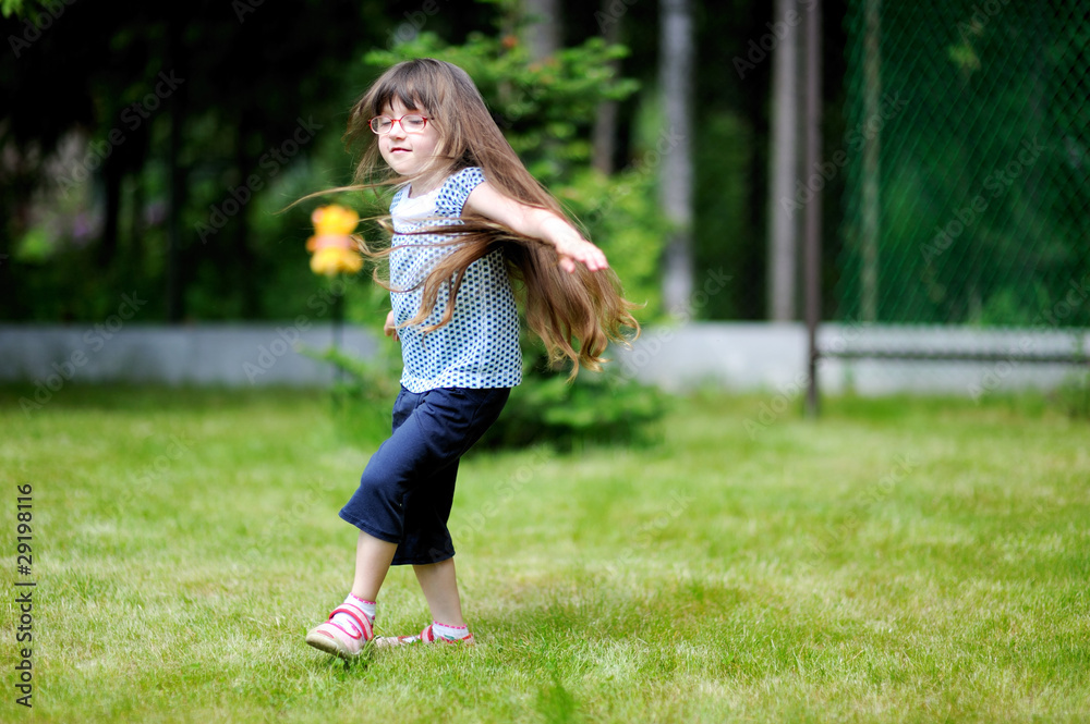 Adorable active little girl plays on backyard in spring Adorable active little girl plays on backyard in spring