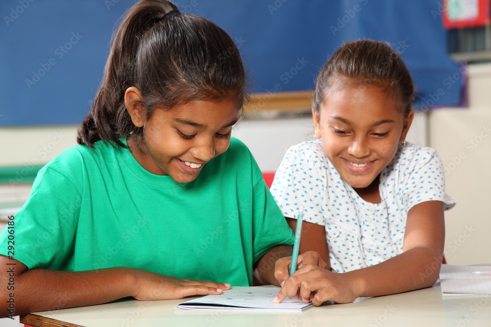 Cheerful school girls in class learning together Cheerful school girls in class learning together