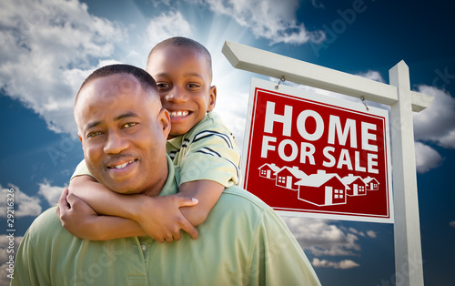 African American Father with Son In Front of Real Estate Sign