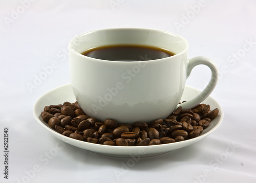 coffee cup on a suacer of beans
