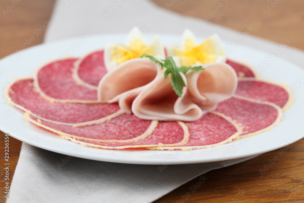 Salami with parmesan crust on a plate with ham and eggs Salami with parmesan crust on a plate with ham and eggs
