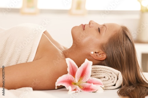 Portrait of young woman sleeping on massage bed