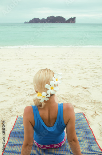 Woman lying on the beach with flowers in her hair