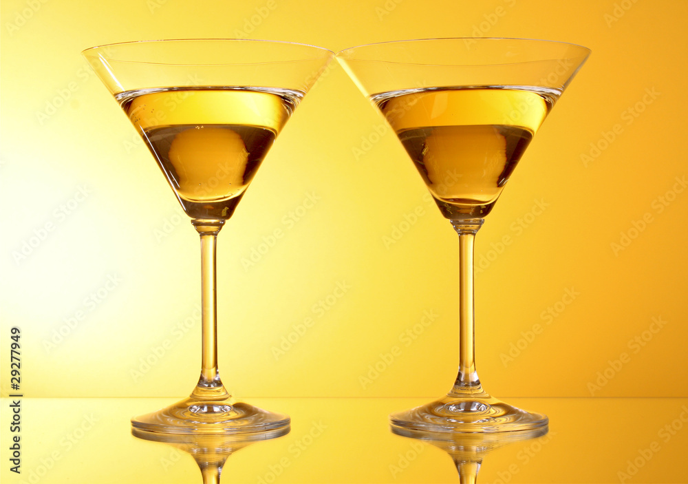 two glasses of martini on a yellow background two glasses of martini on a yellow background
