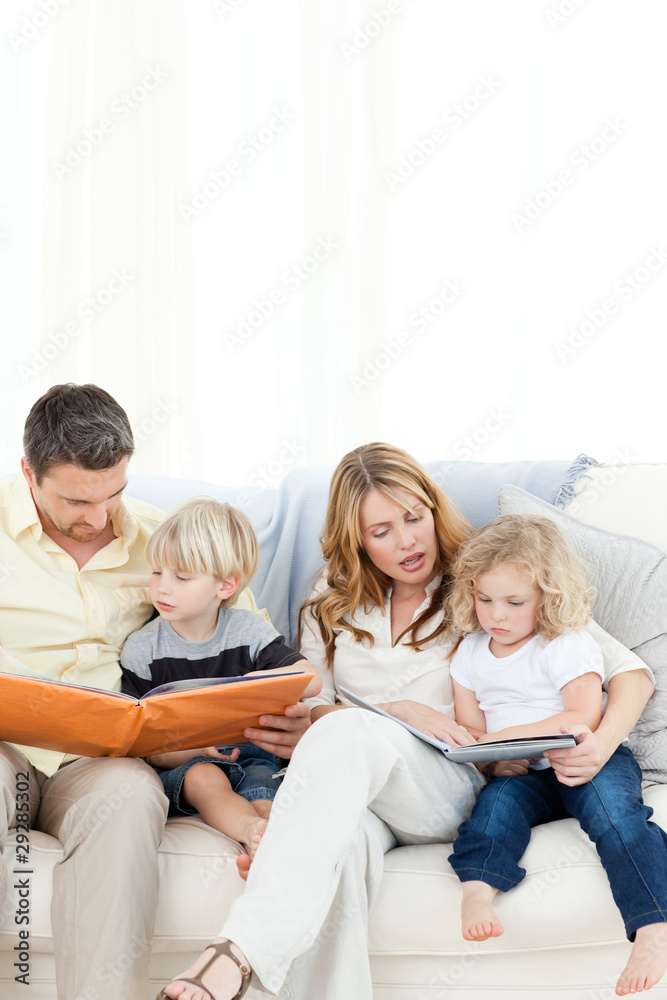 Family reading a book on their sofa