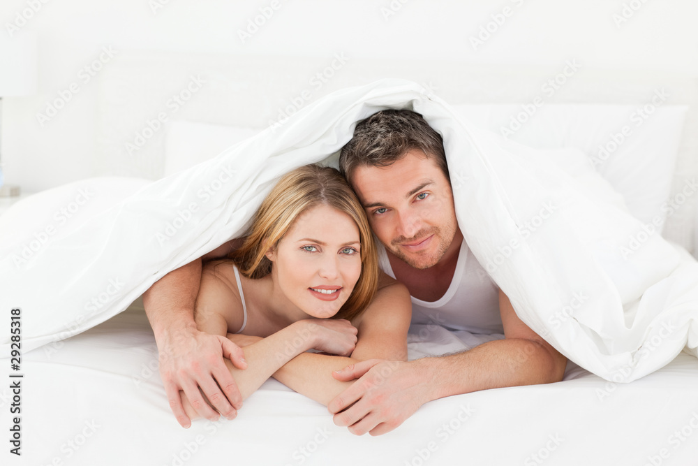 Lovely pair hugging in their bed Lovely pair hugging in their bed