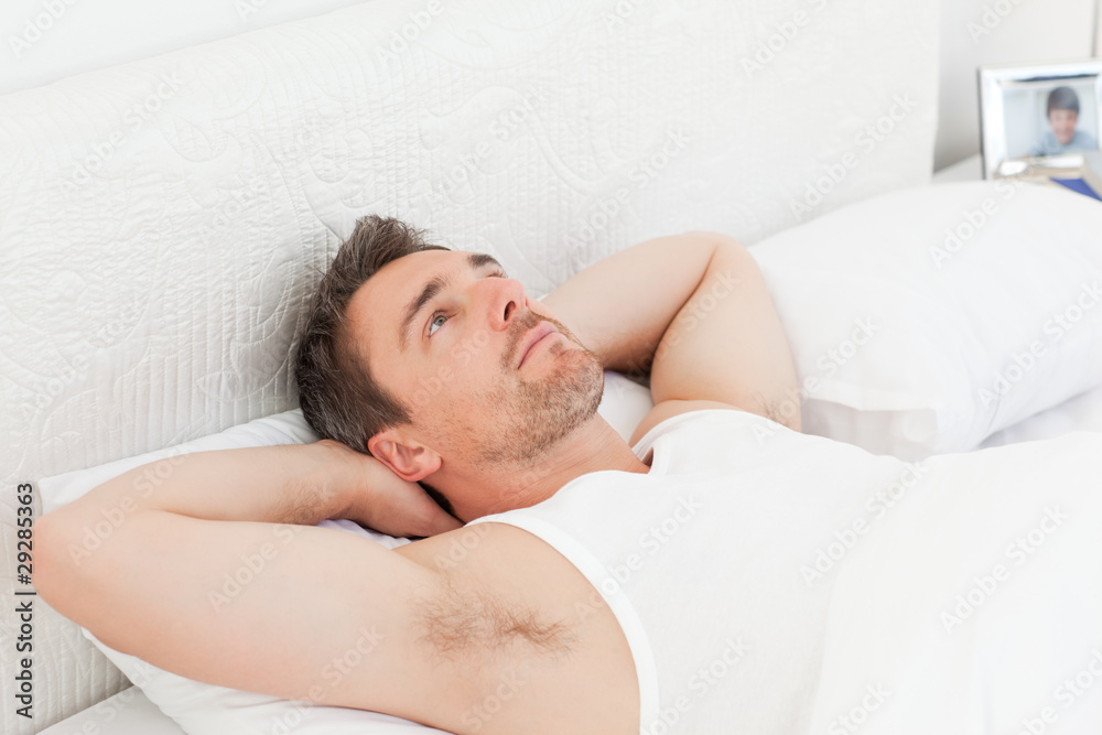 A relaxed man in his bed before waking up A relaxed man in his bed before waking up