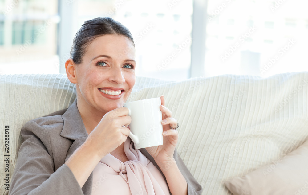 Happy businesswoman drinking a cup of coffee