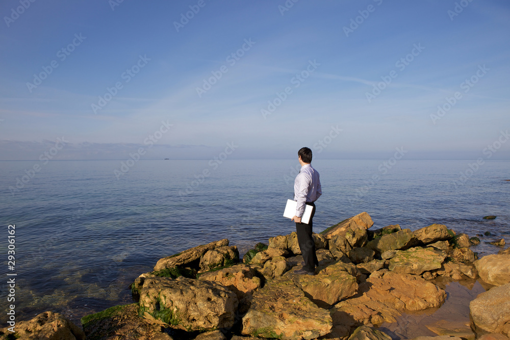 Man near sea with laptop